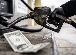 Irán a EEUU: Ustedes fueron quienes iniciaron esta guerra Manguera de gasolina junto a un billete de dólar que representa el costo del combustible.