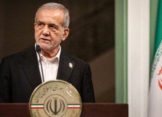 Irán defiende su soberanía y la estabilidad regional Presidente de Irán durante una intervención pública junto a la bandera iraní.