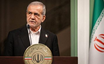 Irán defiende su soberanía y la estabilidad regional Presidente de Irán durante una intervención pública junto a la bandera iraní.