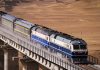 China e Irán activan nueva ruta ferroviaria de carga Tren de carga con contenedores circula por un puente en una zona desértica.