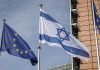 Israel enfrenta sanciones, pero mantiene comercio con Europa Banderas de la Unión Europea e Israel ondean frente a un edificio institucional.