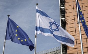Israel enfrenta sanciones, pero mantiene comercio con Europa Banderas de la Unión Europea e Israel ondean frente a un edificio institucional.