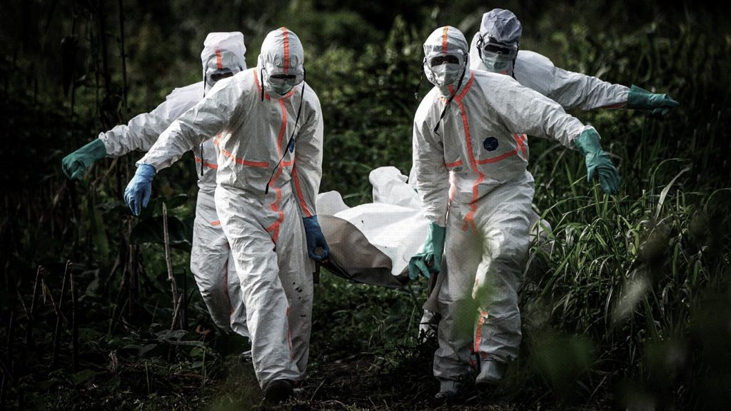 Trabajadores funerarios, protegidos con trajes especiales, transportan los restos del erudito islámico Mussa Kathembo, fallecido a causa del ébola, en Beni, República Democrática del Congo.