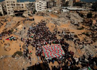 Gaza permanece bajo ataques pese a un año de alto al fuego Familiares se reúnen alrededor de los restos cubiertos con banderas de palestinos muertos en ataques israelíes.