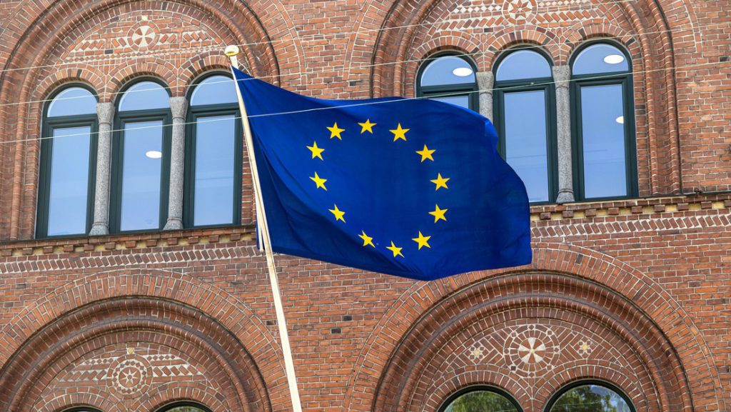 Bandera de la Unión Europea ondeando frente a un edificio