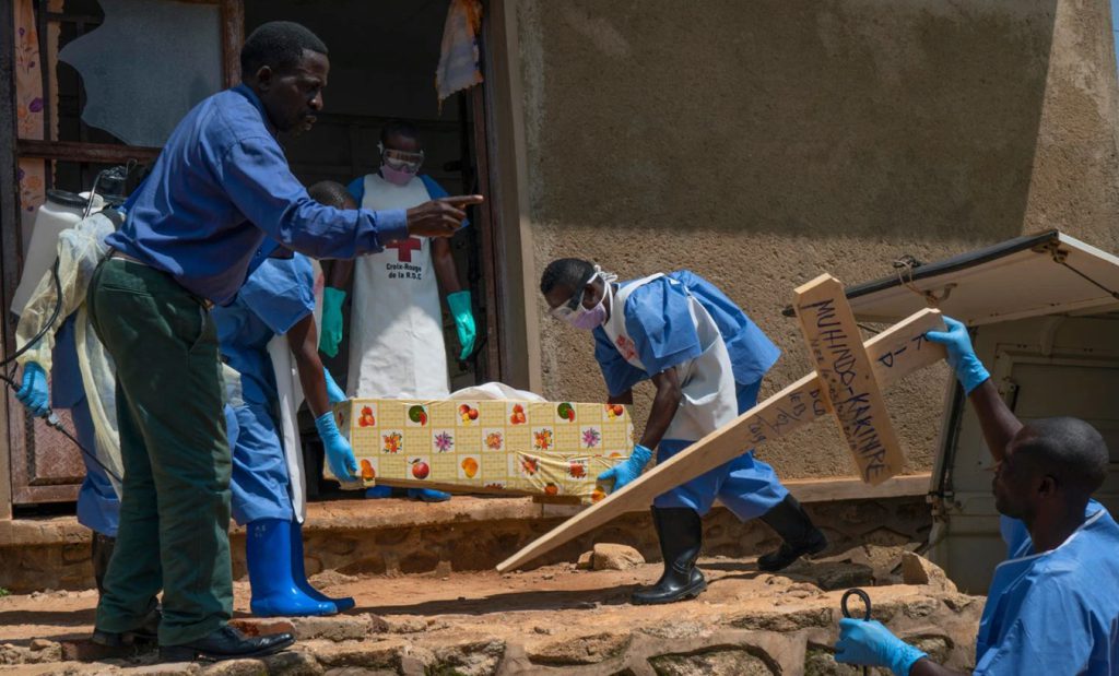 Personal de la Cruz Roja traslada los restos de un bebé de 16 meses desde la morgue, mientras trabajadores sanitarios desinfectan el área en Beni, República Democrática del Congo, en medio del brote de ébola.