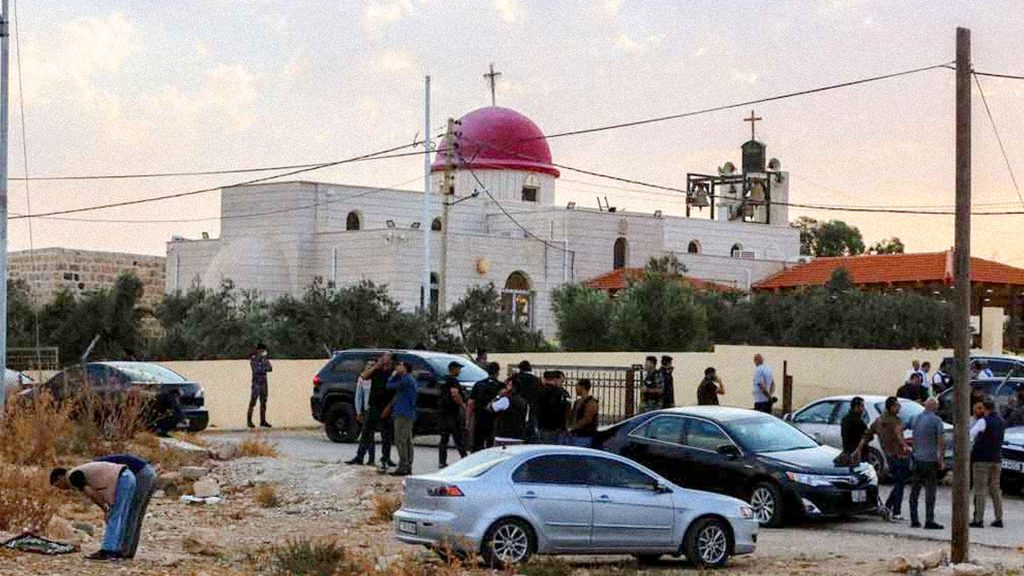 Policías y vehículos frente a una iglesia en Karak, Jordania, tras un ataque armado.