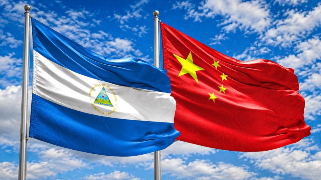 Banderas de Nicaragua y China ondeando juntas bajo un cielo azul.
