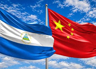 China rechaza acusaciones de Estados Unidos contra empresas mineras en Nicaragua Banderas de Nicaragua y China ondeando juntas bajo un cielo azul.