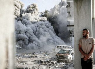 Soldados israelíes revelan masacres de civiles en Gaza Bombardeo israelí en Gaza con edificios dañados, vehículos destruidos y una columna de humo.