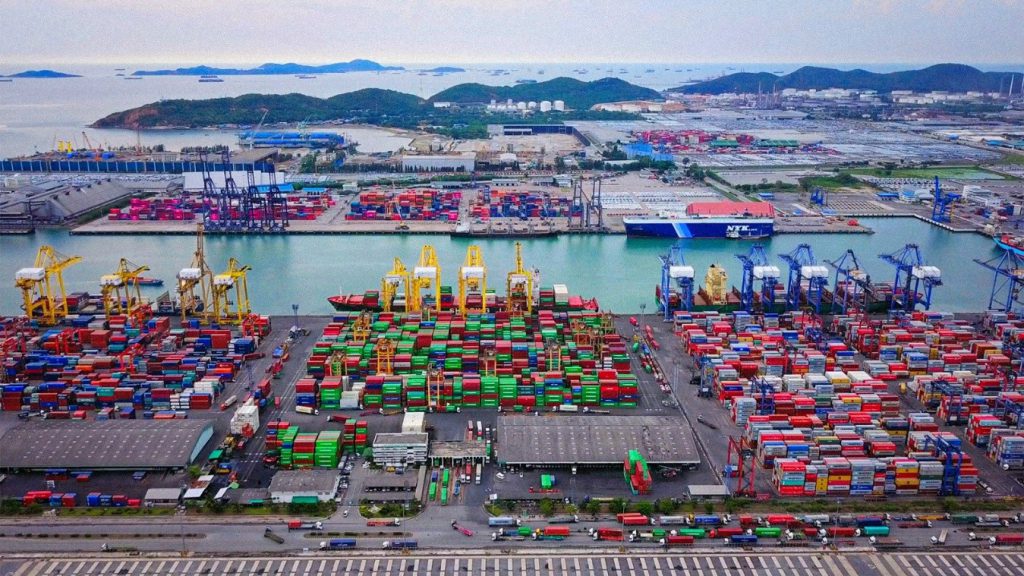 Puerto de contenedores en China con grúas y mercancías destinadas al comercio internacional.