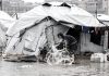 Gaza, un techo de lona frente a la tormenta Niño palestino sacando agua de una tienda inundada en Gaza ante la crisis de refugio.