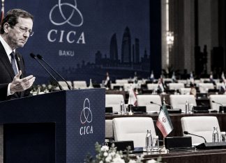 Israel vuelve a quedarse hablando solo: Esta vez en la cumbre CICA Presidente israelí en el podio durante la cumbre CICA en Bakú, con banderas de Irán y Emiratos Árabes Unidos en la sala.