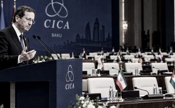 Israel vuelve a quedarse hablando solo: Esta vez en la cumbre CICA Presidente israelí en el podio durante la cumbre CICA en Bakú, con banderas de Irán y Emiratos Árabes Unidos en la sala.