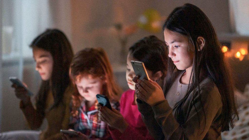 Menores utilizan teléfonos móviles mientras Meta enfrenta una demanda en Australia por el uso de sus redes sociales.