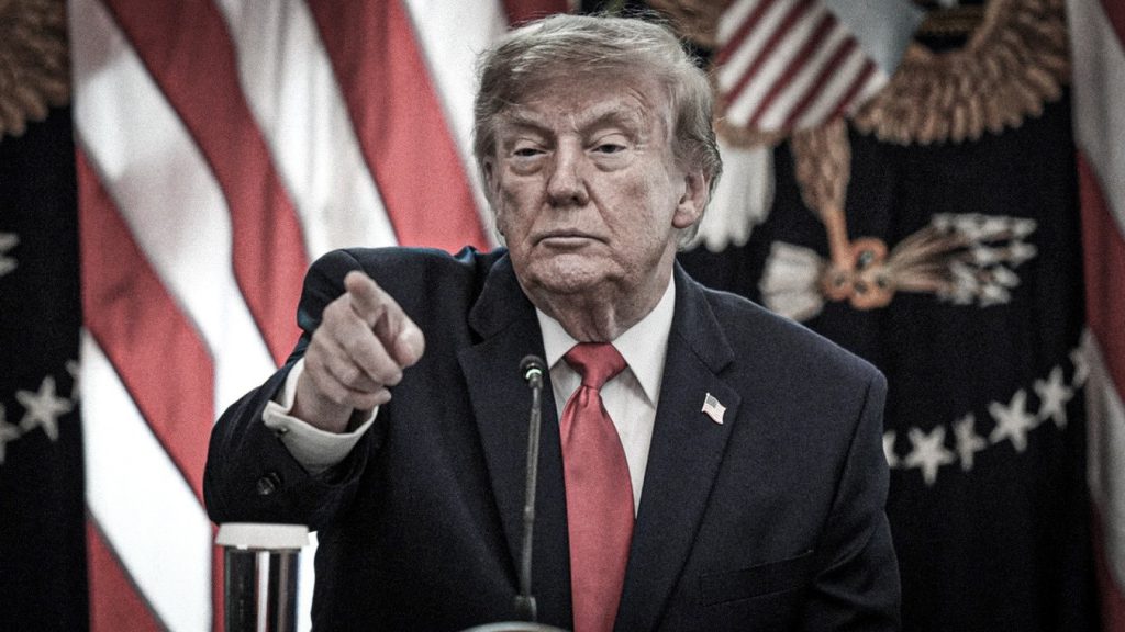 Donald Trump señala al público durante una intervención frente a las banderas de Estados Unidos.