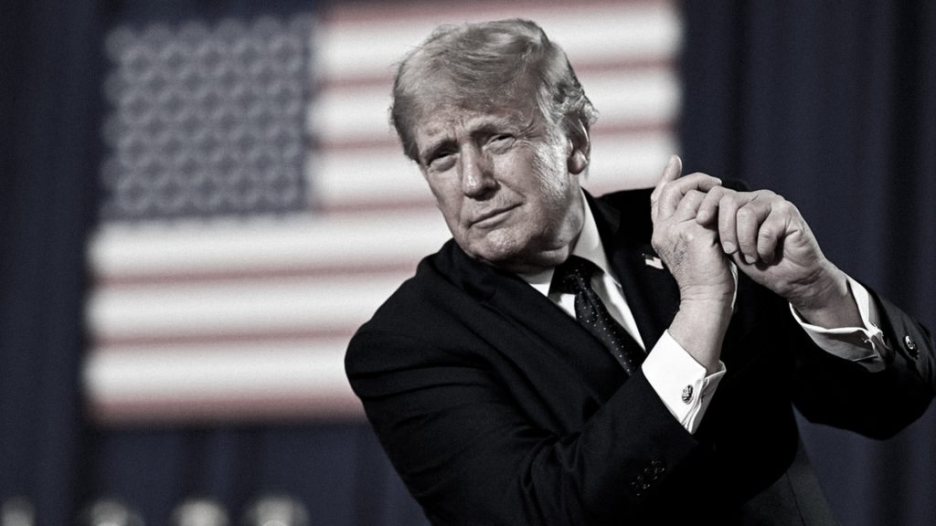 Donald Trump durante un acto político con la bandera de Estados Unidos al fondo.