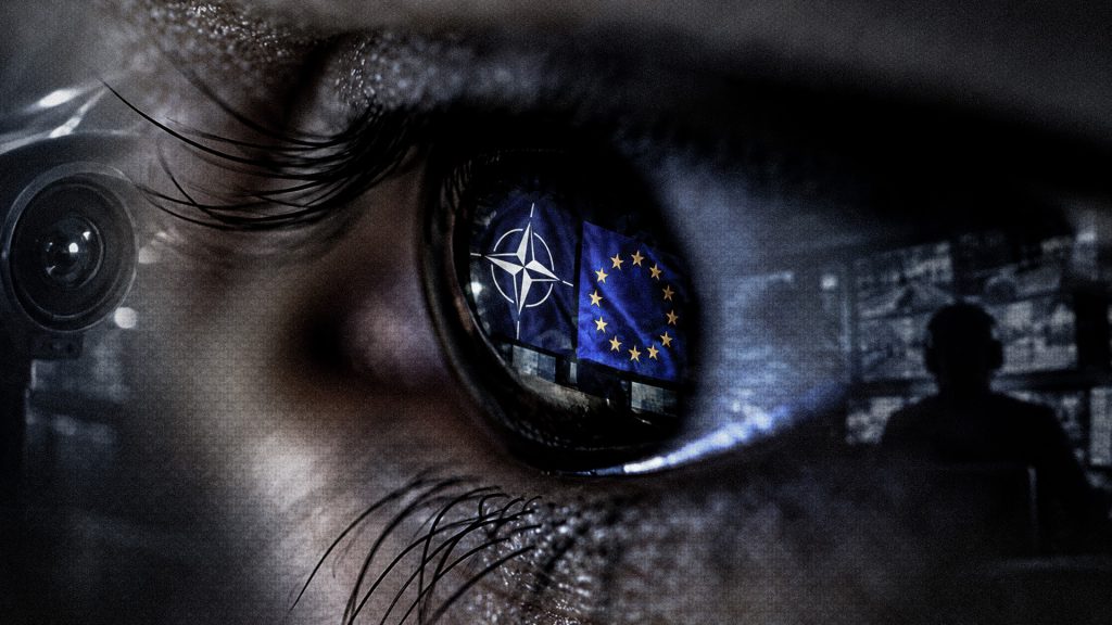 Imagen conceptual de vigilancia digital con los símbolos de la OTAN y la Unión Europea reflejados en un ojo.