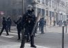 Francia despliega 70.000 policías ante protestas contra Macron Policías antidisturbios franceses equipados con escudos durante un operativo de seguridad en una calle.