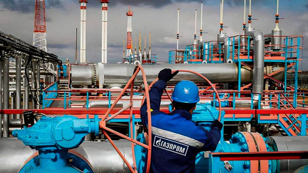 Trabajador de Gazprom junto a tuberías y válvulas de una instalación industrial de gas rusa.