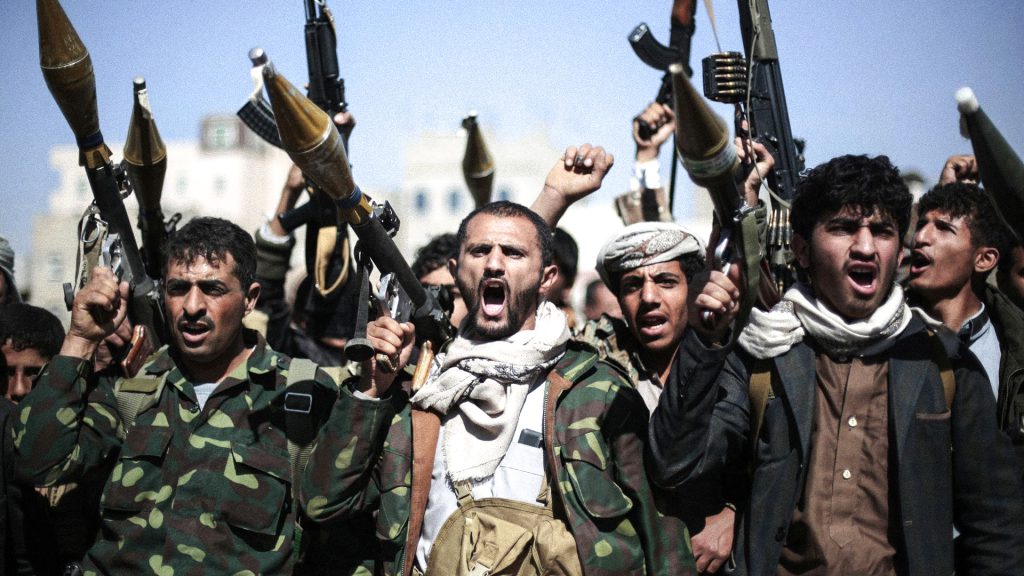 Combatientes hutíes en Yemen portan armas durante una concentración pública.