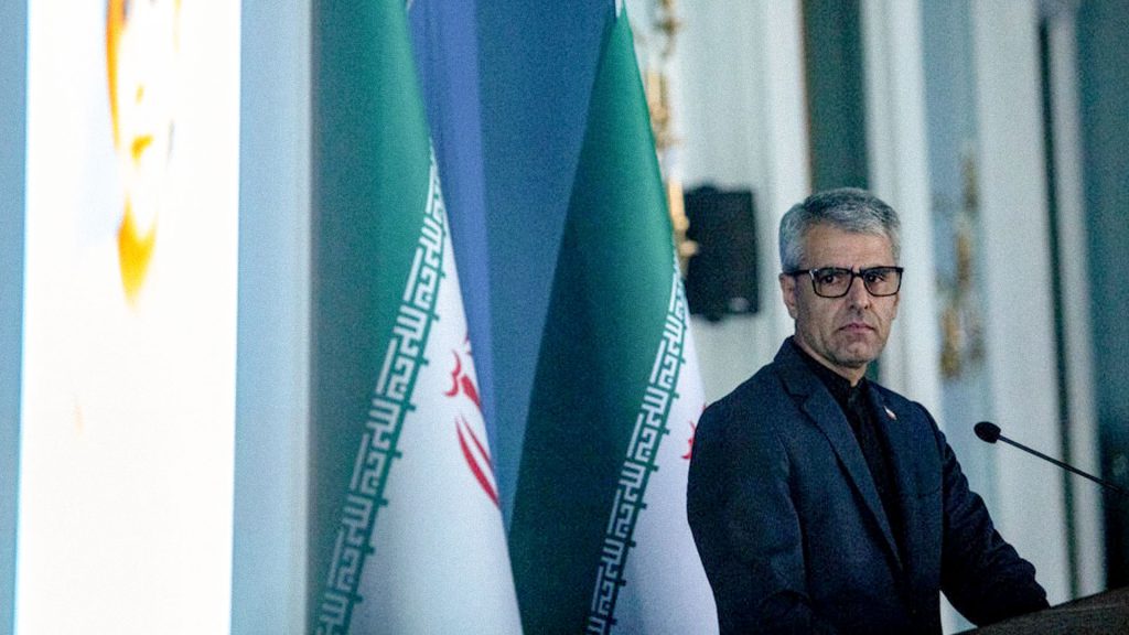 Portavoz de Exteriores de Irán, Esmaeil Baqaei, durante una conferencia de prensa junto a la bandera iraní.