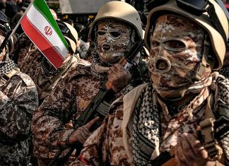 Irán lanza ultimátum a Estados Unidos: ¡Fuera de la región! Soldados iraníes con uniformes de camuflaje y una bandera nacional durante un desfile militar en Teherán.