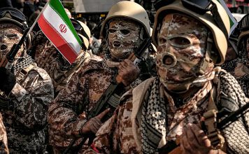 Irán lanza ultimátum a Estados Unidos: ¡Fuera de la región! Soldados iraníes con uniformes de camuflaje y una bandera nacional durante un desfile militar en Teherán.