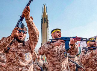 Irán se prepara ante nueva alerta de ataques estadounidenses Militares iraníes armados durante una exhibición militar con un misil al fondo.