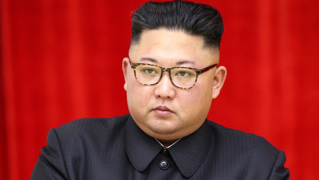 Kim Jong-un, líder norcoreano, frente a un fondo rojo durante un acto oficial.