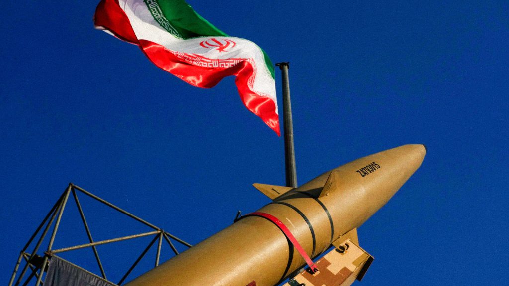 Misil iraní exhibido junto a la bandera de Irán en una exposición militar en Teherán.