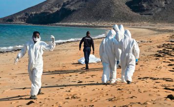 Naufragio en Yibuti deja 139 migrantes muertos y 84 desaparecidos Personal de emergencia con trajes de protección durante labores de recuperación en una playa de Yibuti.
