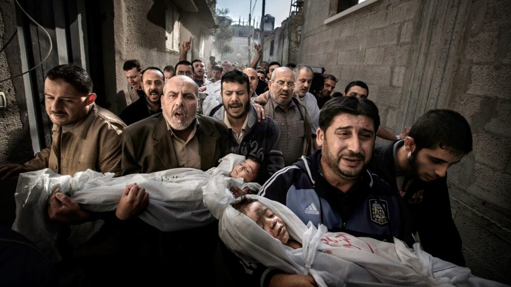 Palestinos trasladan los cuerpos de dos niños en Gaza durante la crisis humanitaria provocada por los ataques israelíes.