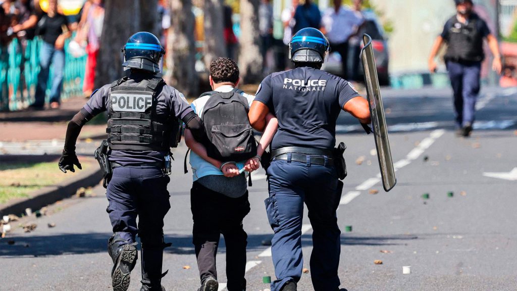 Policías franceses trasladan a un manifestante detenido durante las protestas en Francia.