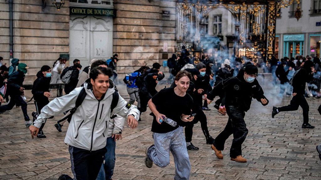 Estudiantes corren durante enfrentamientos con la Policía en Nancy, Francia, en una protesta vinculada a la crisis educativa.
