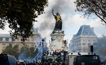 Europa en crisis: ola de protestas sacude el continente Manifestantes y fuerzas policiales durante protestas en la plaza de la República, en París, entre humo y vehículos policiales.
