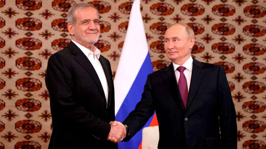El presidente ruso, Vladimir Putin, estrecha la mano del presidente iraní, Masoud Pezeshkian, durante su reunión en octubre de 2024, en Ashgabat, Turkmenistán.